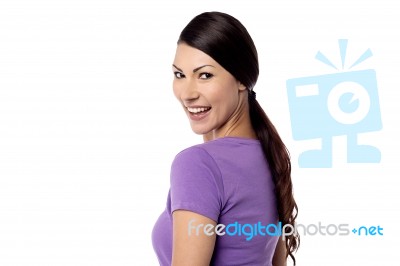 Smiling Woman Looking Over Shoulder Stock Photo