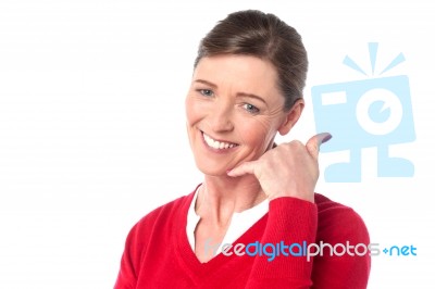 Smiling Woman Making A Call Me Gesture Stock Photo