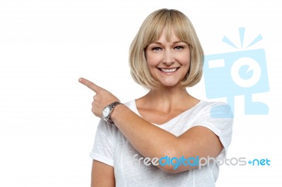 Smiling Woman Pointing Backwards Stock Photo