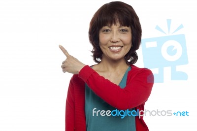 Smiling Woman Pointing Upward Stock Photo