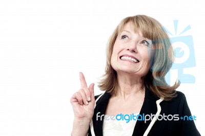 Smiling Woman Pointing Upwards Stock Photo