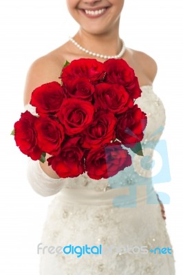 Smiling Young Bride Holding Out A Rose Bouquet Stock Photo