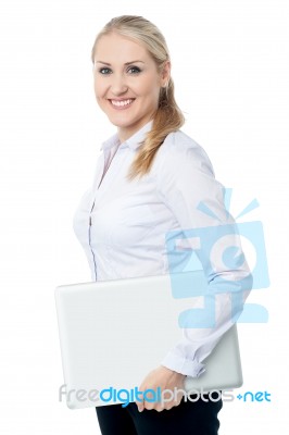 Smiling Young Corporate Woman With Laptop Stock Photo