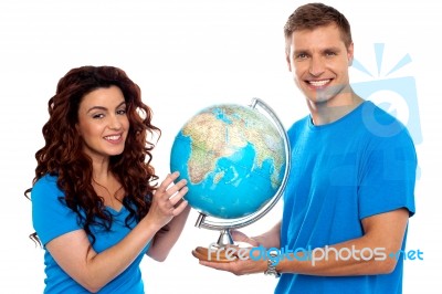 Smiling Young Couple Holding Globe Stock Photo