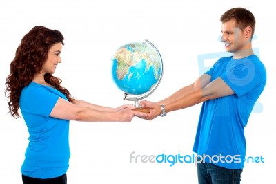 Smiling Young Couple Holding Globe Stock Photo