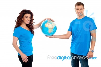 Smiling Young Couple Holding Globe Stock Photo