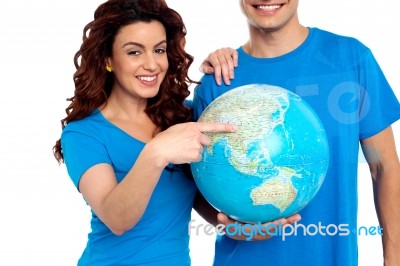 Smiling Young Couple Holding Globe Stock Photo