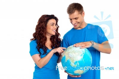 Smiling Young Couple Holding Globe Stock Photo