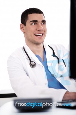 Smiling Young Doctor At His Office Stock Photo