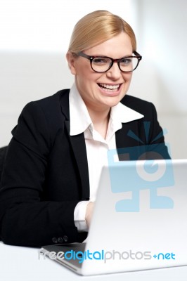 Smiling Young Female Executive At Work Desk Stock Photo