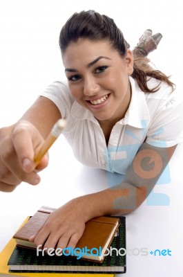 Smiling Young Girl Giving Pencil Stock Photo