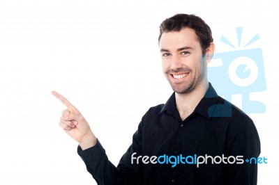 Smiling Young Guy Pointing At Something Stock Photo