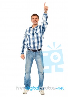 Smiling Young Guy Pointing Upwards Stock Photo