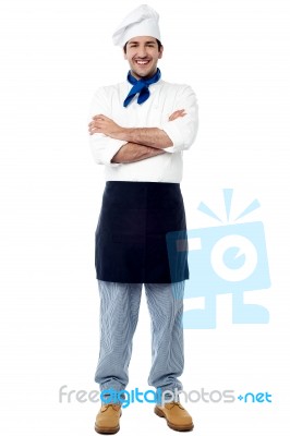 Smiling Young Male Chef With Arms Crossed Stock Photo