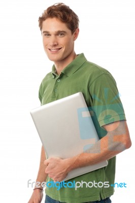 Smiling Young Man Holding Laptop Stock Photo