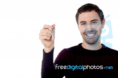 Smiling Young Man Showing Key Stock Photo