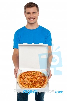 Smiling Young Man Showing Pizza Stock Photo