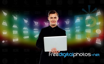 Smiling Young Man Standing With Laptop Stock Photo