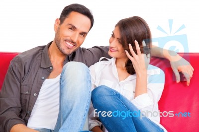 Smiling Young Man With Girlfriend On Sofa Stock Photo