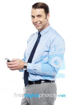 Smiling Young Manger Sending Sms From Phone Stock Photo