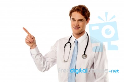 Smiling Young Physician Pointing Away Stock Photo