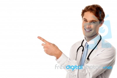 Smiling Young Physician Pointing Away Stock Photo