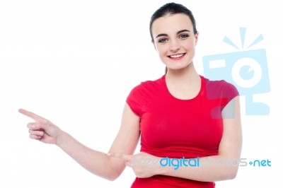 Smiling Young Woman Pointing To Her Right Stock Photo