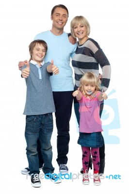 Snapshot Of A Successful Family Gesturing Thumbs Up Stock Photo