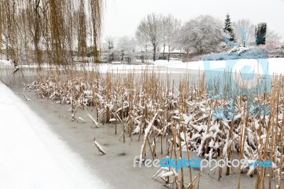 Snow And Ice On Water Of Pond Stock Photo