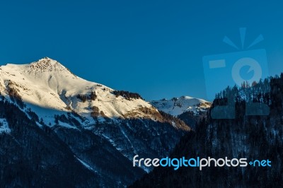 Snowy Mountain Tops In The Blue Sky Sun Stock Photo