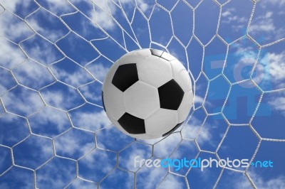 Soccer Ball In Goal Net With Blue Sky Stock Photo