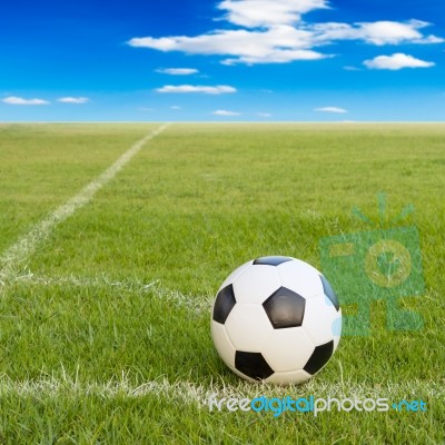 Soccer Ball On Soccer Field Against Blue Sky Stock Photo