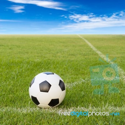 Soccer Ball On Soccer Field Against Blue Sky Stock Photo