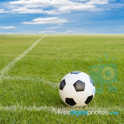 Soccer Ball On Soccer Field Against Blue Sky Stock Photo