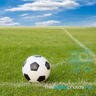 Soccer Ball On Soccer Field Against Blue Sky Stock Photo