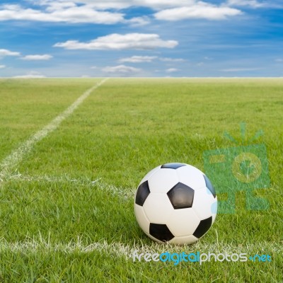 Soccer Ball On Soccer Field Against Blue Sky Stock Photo