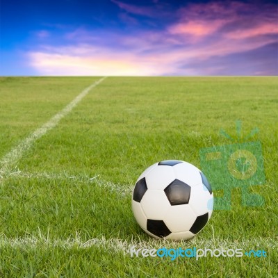 Soccer Ball On Soccer Field Against Sunset Sky Stock Photo