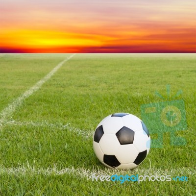 Soccer Ball On Soccer Field Against Sunset Sky Stock Photo