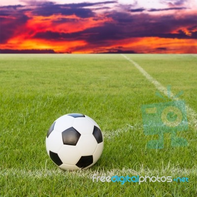 Soccer Ball On Soccer Field Against Sunset Sky Stock Photo