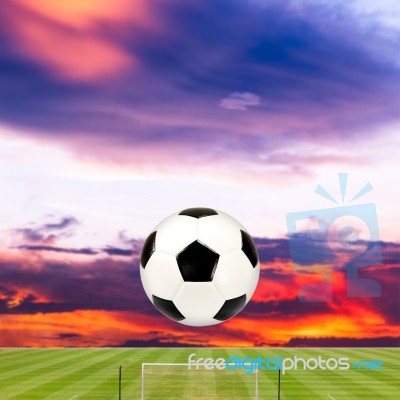 Soccer Ball With Soccer Field Against Beautiful Sunset Stock Photo