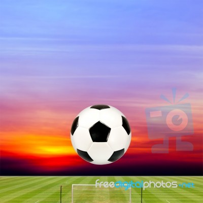 Soccer Ball With Soccer Field Against Beautiful Sunset Stock Photo