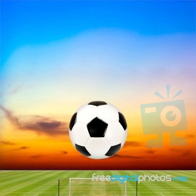 Soccer Ball With Soccer Field Against Beautiful Sunset Stock Photo