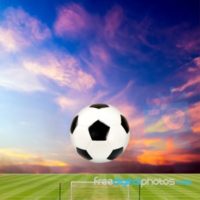 Soccer Ball With Soccer Field Against Beautiful Sunset Stock Photo