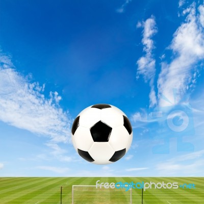 Soccer Ball With Soccer Field Against  Blue Sky Background Stock Photo