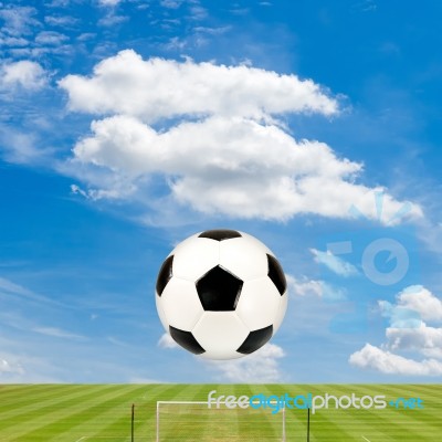 Soccer Ball With Soccer Field Against  Blue Sky Background Stock Photo