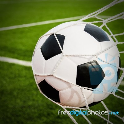 Soccer Football In Goal Net With Green Grass Field Stock Photo