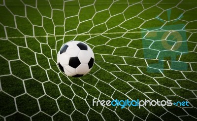 Soccer Football In Goal Net With Green Grass Field Stock Photo