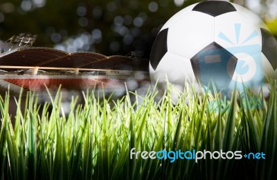 Soccer Football On Green Field With Stadium Background Stock Photo