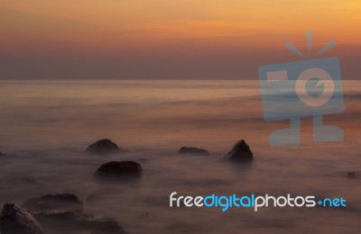 Soft Waves On A Rocky Beach In The Evening Stock Photo