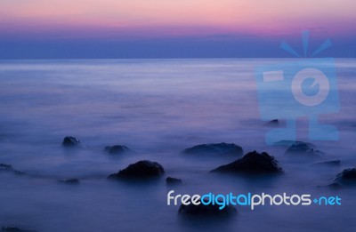 Soft Waves On A Rocky Beach In The Evening Stock Photo